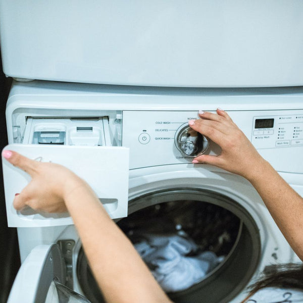 a person putting detergent in washer