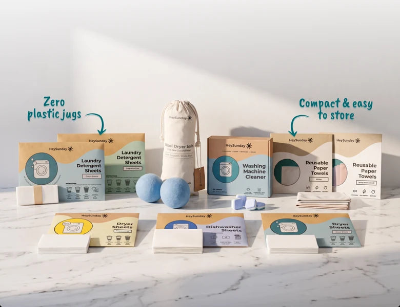 HeySunday laundry, dryer, dishwasher sheets, wool dryer balls, washing machine cleaner and reusable paper towels arranged on a marble counter