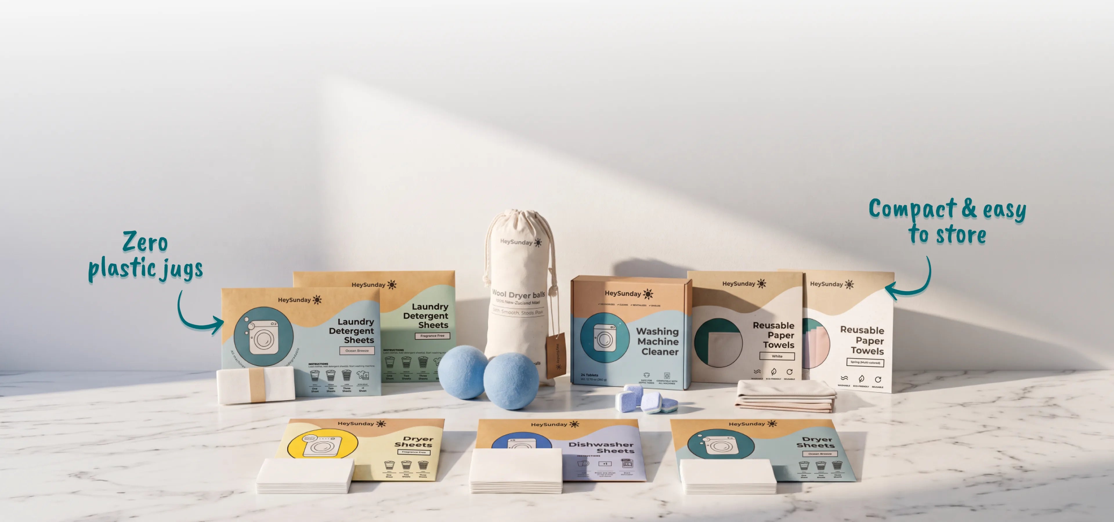 HeySunday laundry, dryer, dishwasher sheets, wool dryer balls, washing machine cleaner and reusable paper towels arranged on a marble counter