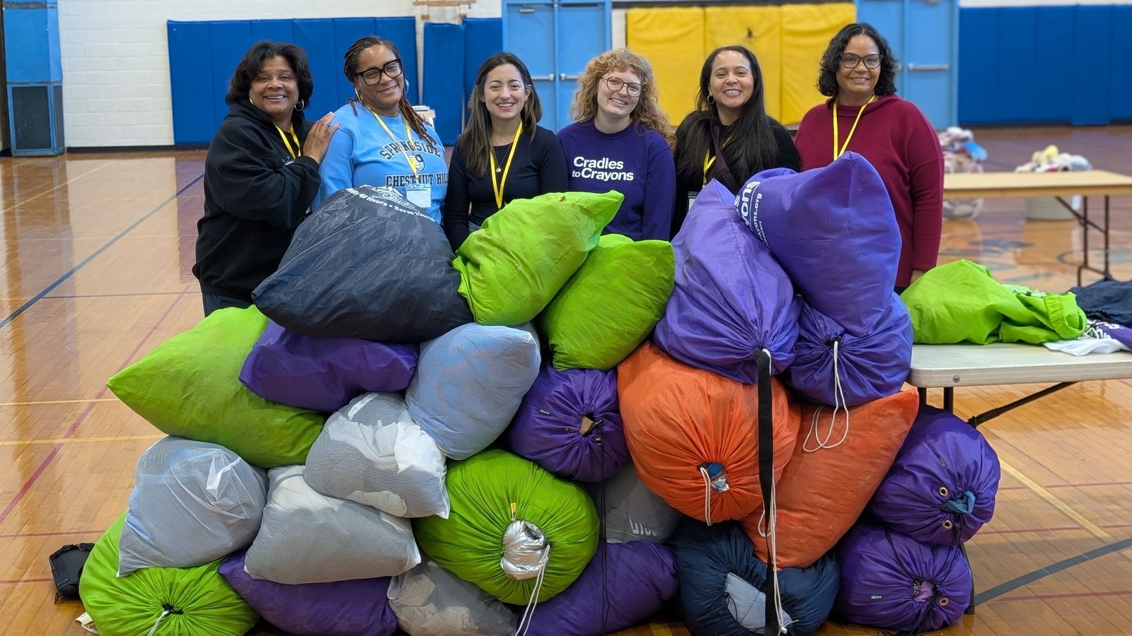 Cradles to Crayons team and volunteers with bags of donated clothing